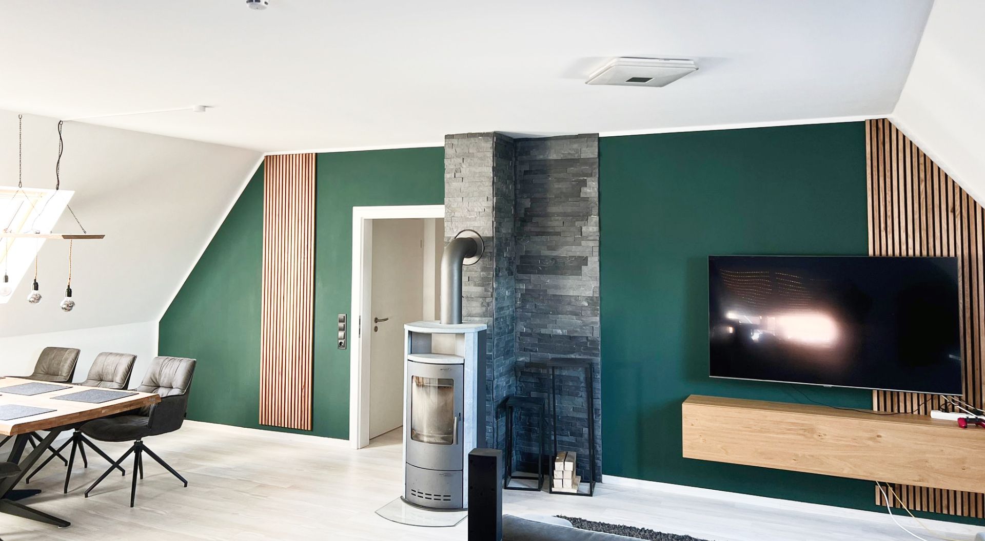 Modernes Wohnzimmer mit grünem Wanddesign und Kamin